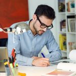 man-writing-on-a-desk_1301-48